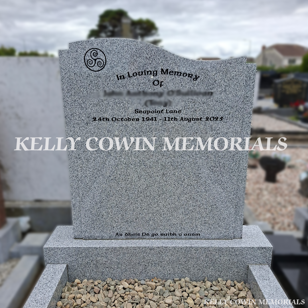 Close up of Grey granite custom headstone with granite kerbing, mixed pebble garden border, granite corner posts and black inscription in St. Peter and Paul's Cemetery, Balbriggan.