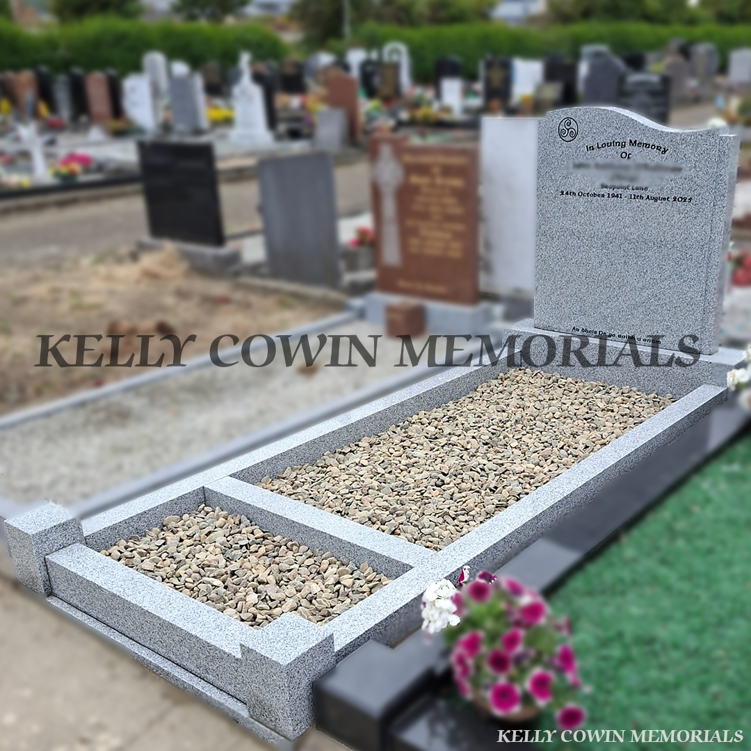 Side view Grey granite custom headstone with granite kerbing, mixed pebble garden border, granite corner posts and black inscription in St. Peter and Paul's Cemetery, Balbriggan.