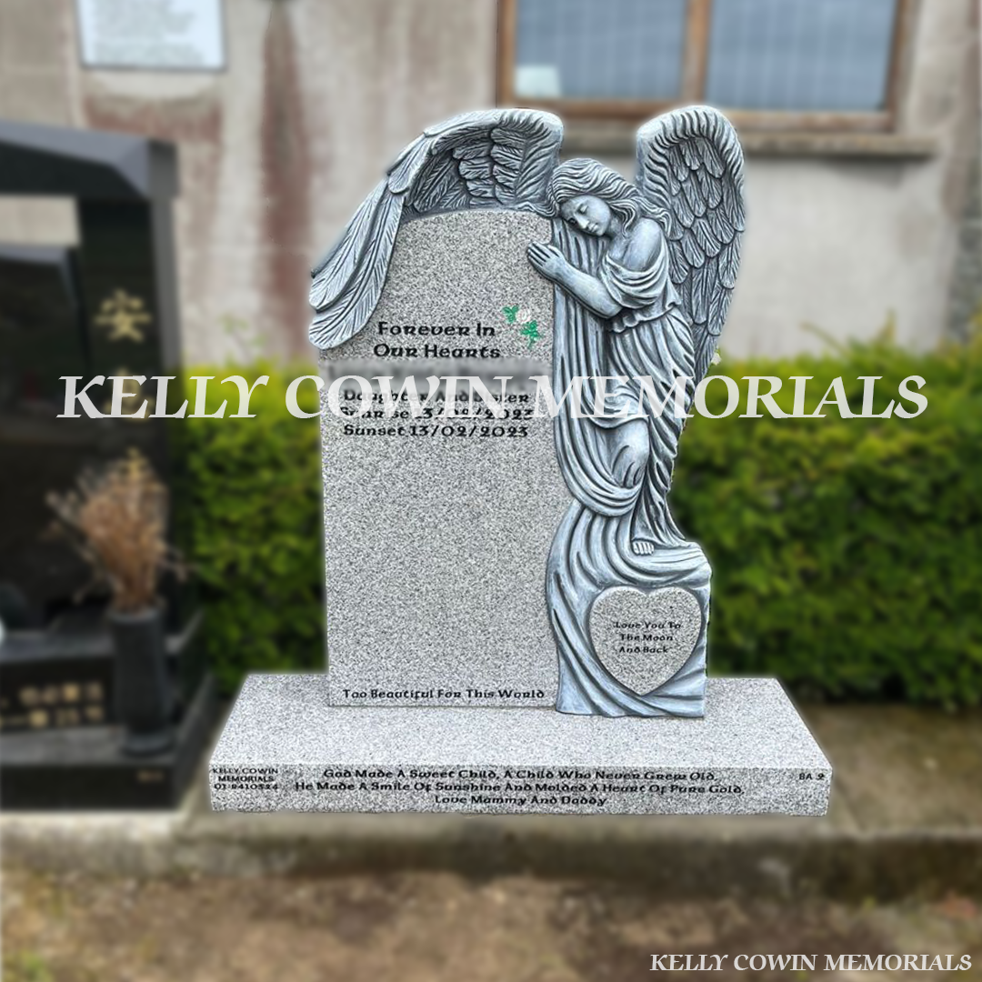 Front view of grey granite antique carved angel headstone with black inscription on a plinth in Flemington Cemetery Dublin