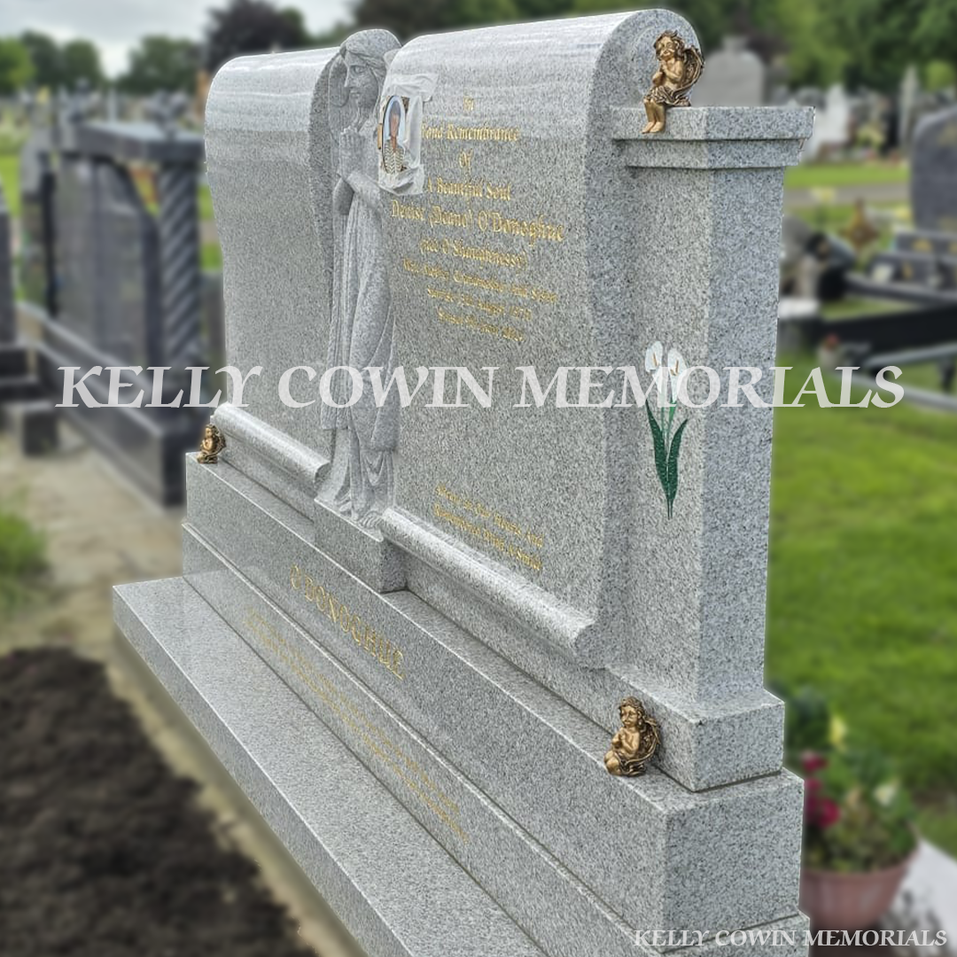 Pearl white double scroll Traveller headstone with carved angel, bronze angels and gold leaf inscription in Mount St Oliver’s Cemetery, Limerick