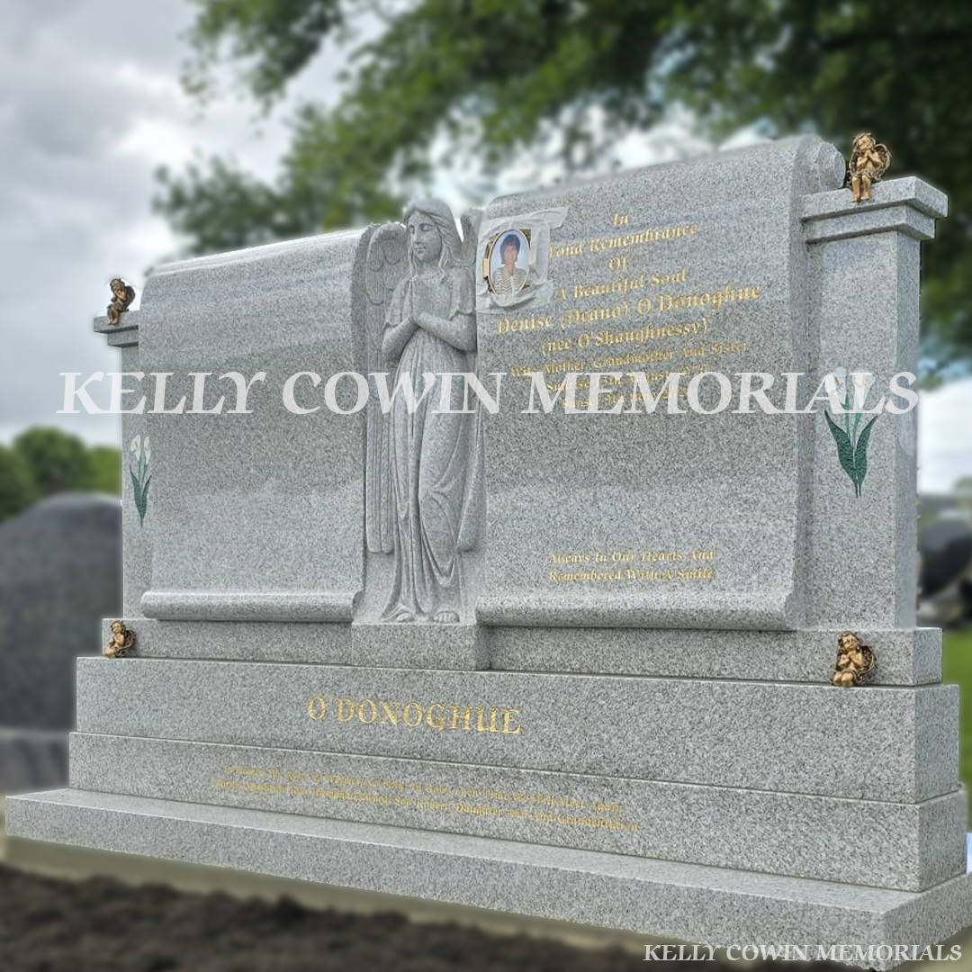 Pearl white double scroll Traveller headstone with carved angel, bronze angels and gold leaf inscription in Mount St Oliver’s Cemetery, Limerick