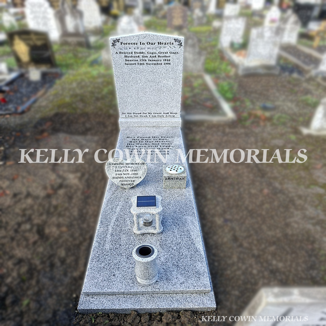 Front view Grey granite headstone with matching kerbing and full-length slab at a completed grave in Glasnevin Cemetery.