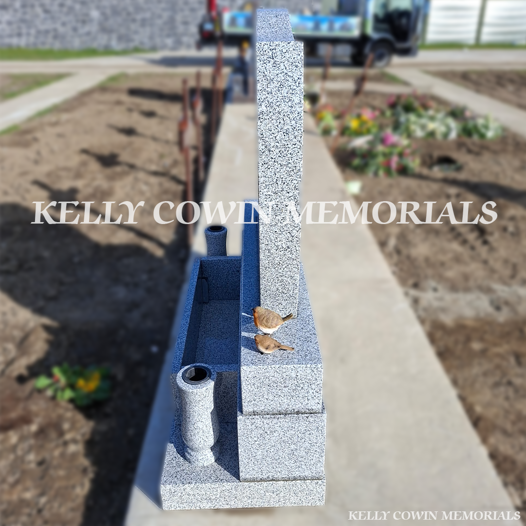 Side view of grey granite memorial with vases and flower box in Balgriffin Cemetery