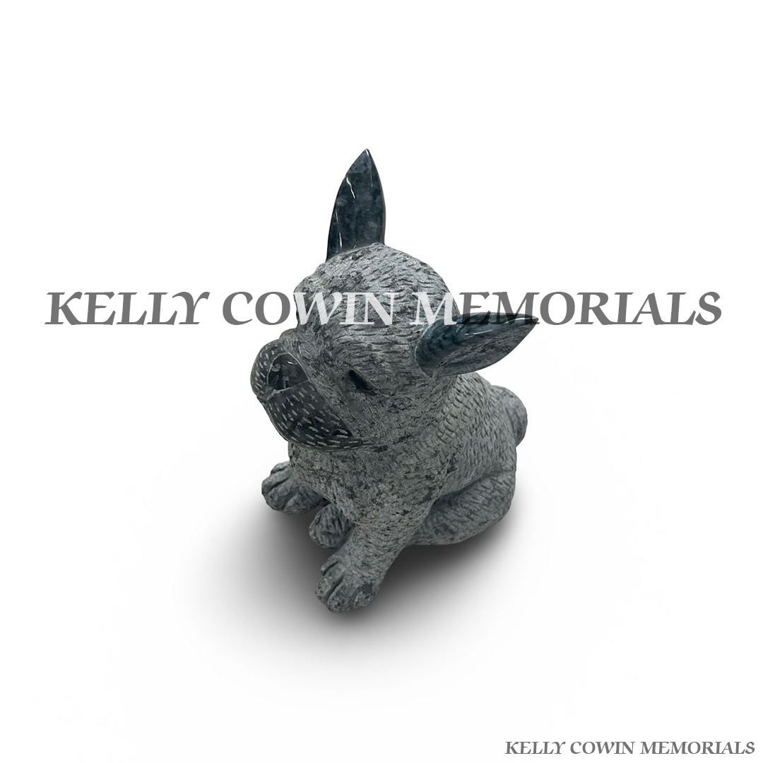 Close-up of hand-carved French Bulldog detail in grey granite memorial statue