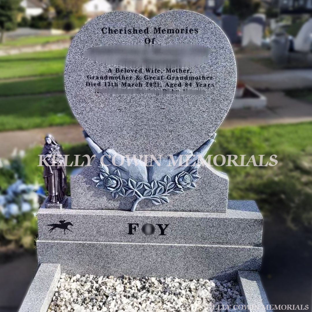 Grey granite antique carved hands holding heart-shaped memorial headstone with kerbing and chippings by Kelly Cowin Memorials Ireland