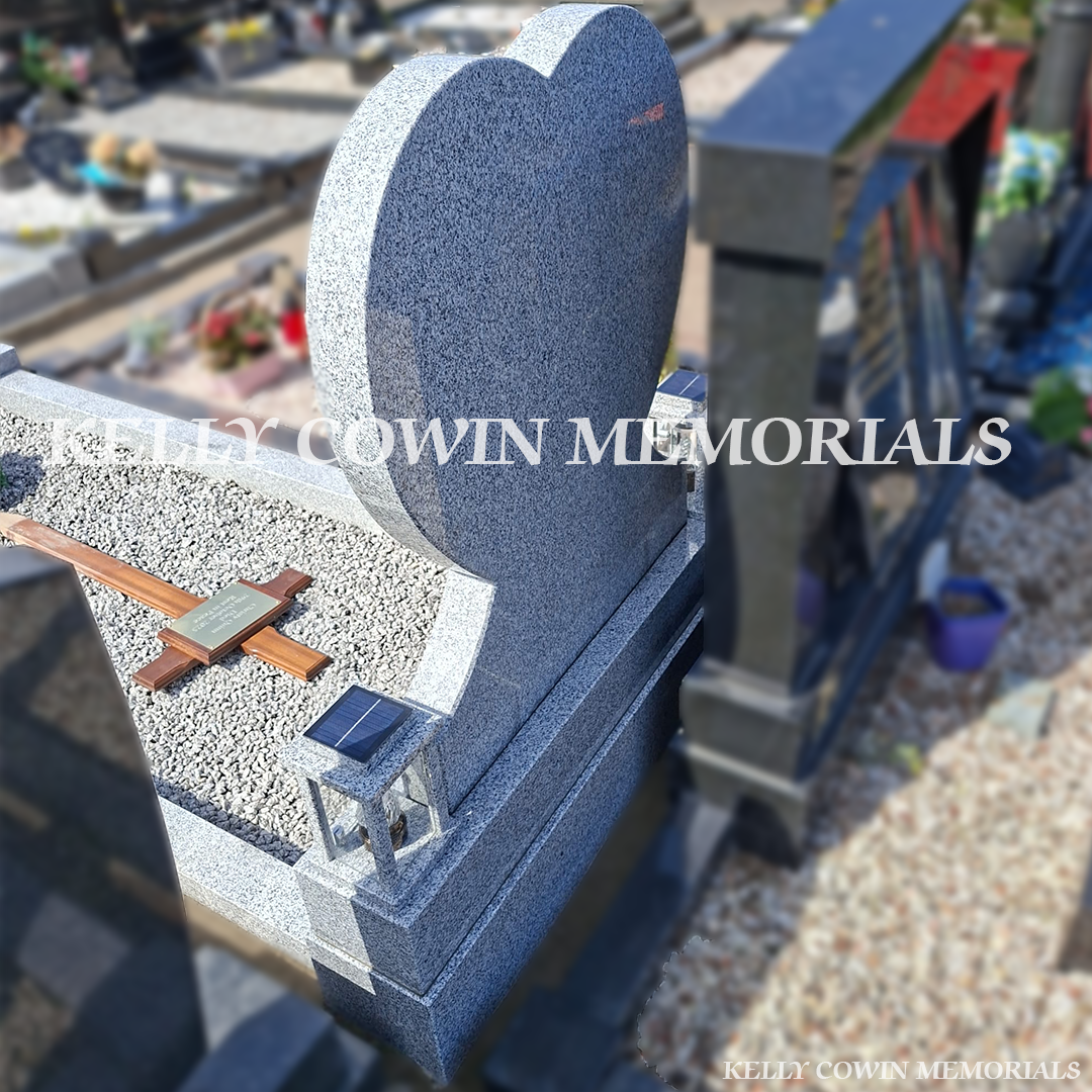 Back view of grey granite memorial with kerbing and solar lanterns