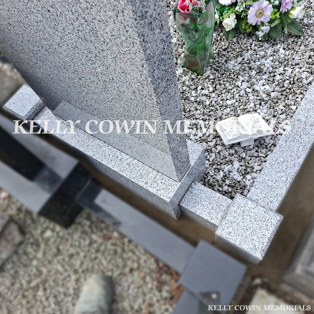 Back view of grey granite memorial with kerbing and chippings
