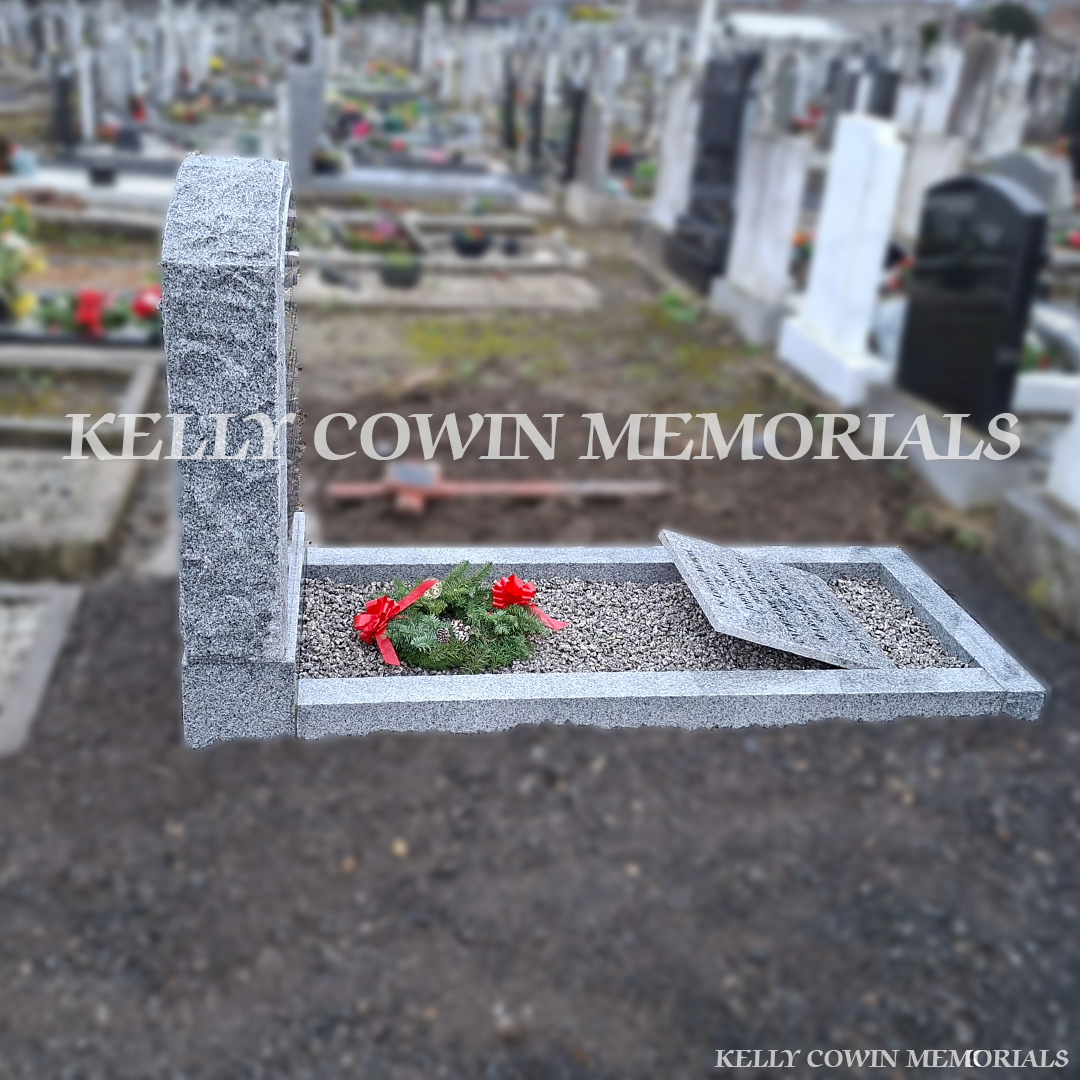 Full side view of grey granite boulder headstone with kerbing in Mount Jerome Cemetery Dublin