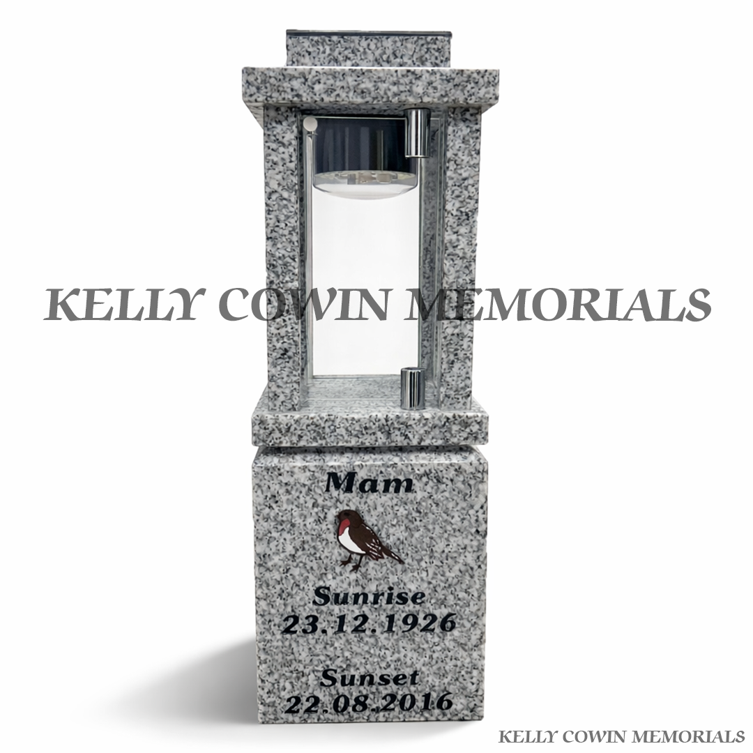 Close-up of engraved robin detail on grey granite solar lantern block