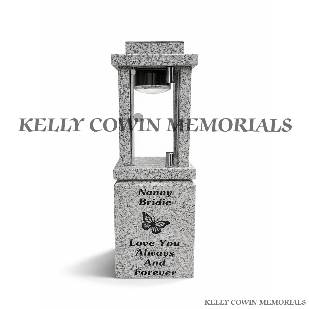 Close-up of engraved butterfly detail on grey granite solar lantern block
