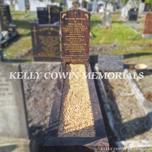 Pandora granite OG headstone with natural red and black granite patterns, gold engraved inscription, cross and floral details, matching granite base, full grave kerbing and Yellow Seena decorative chippings in Glasnevin Cemetery, Dublin, by Kelly Cowin Memorials.