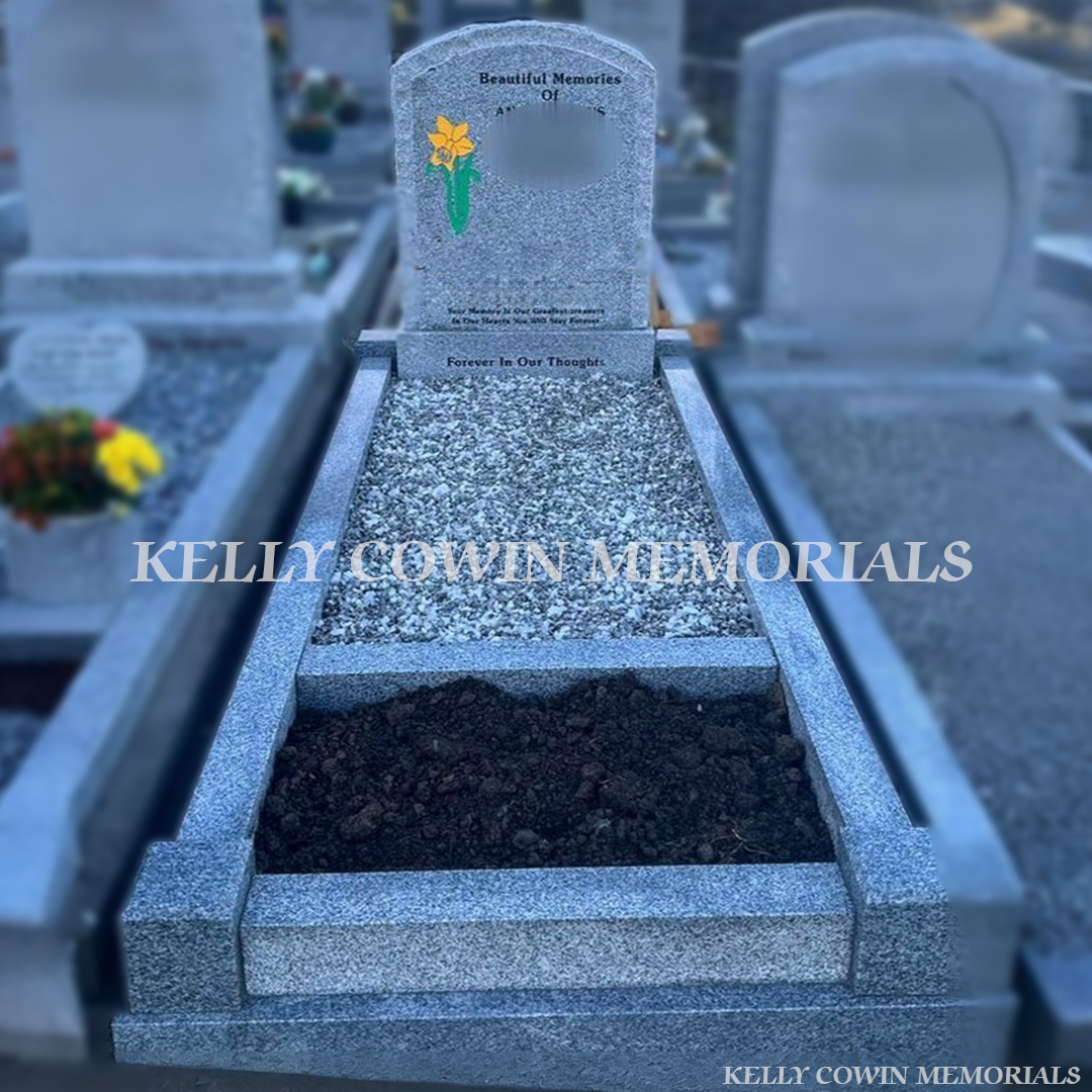 Grey rough edge granite boulder headstone with raised polished face, kerbing, garden area and decorative chippings by Kelly Cowin Memorials Ireland