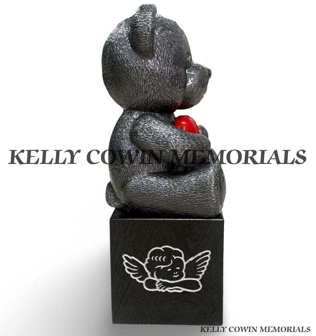 Side view of silver ceramic teddy bear with red heart mounted on a black granite memorial block with engraved angel design by Kelly Cowin Memorials.
