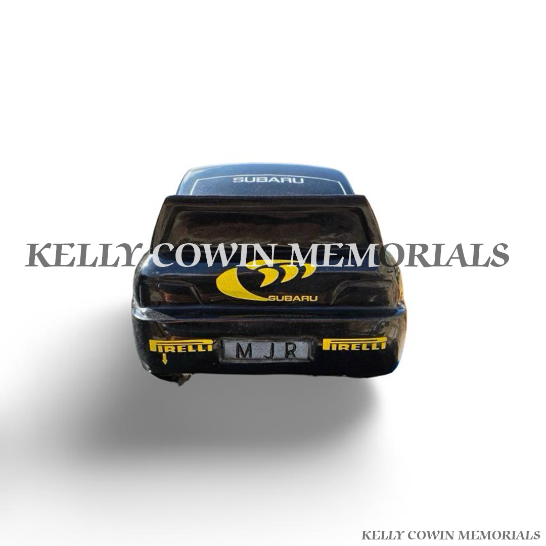 Rear view of custom black granite Subaru car memorial with spoiler and detailed racing design.