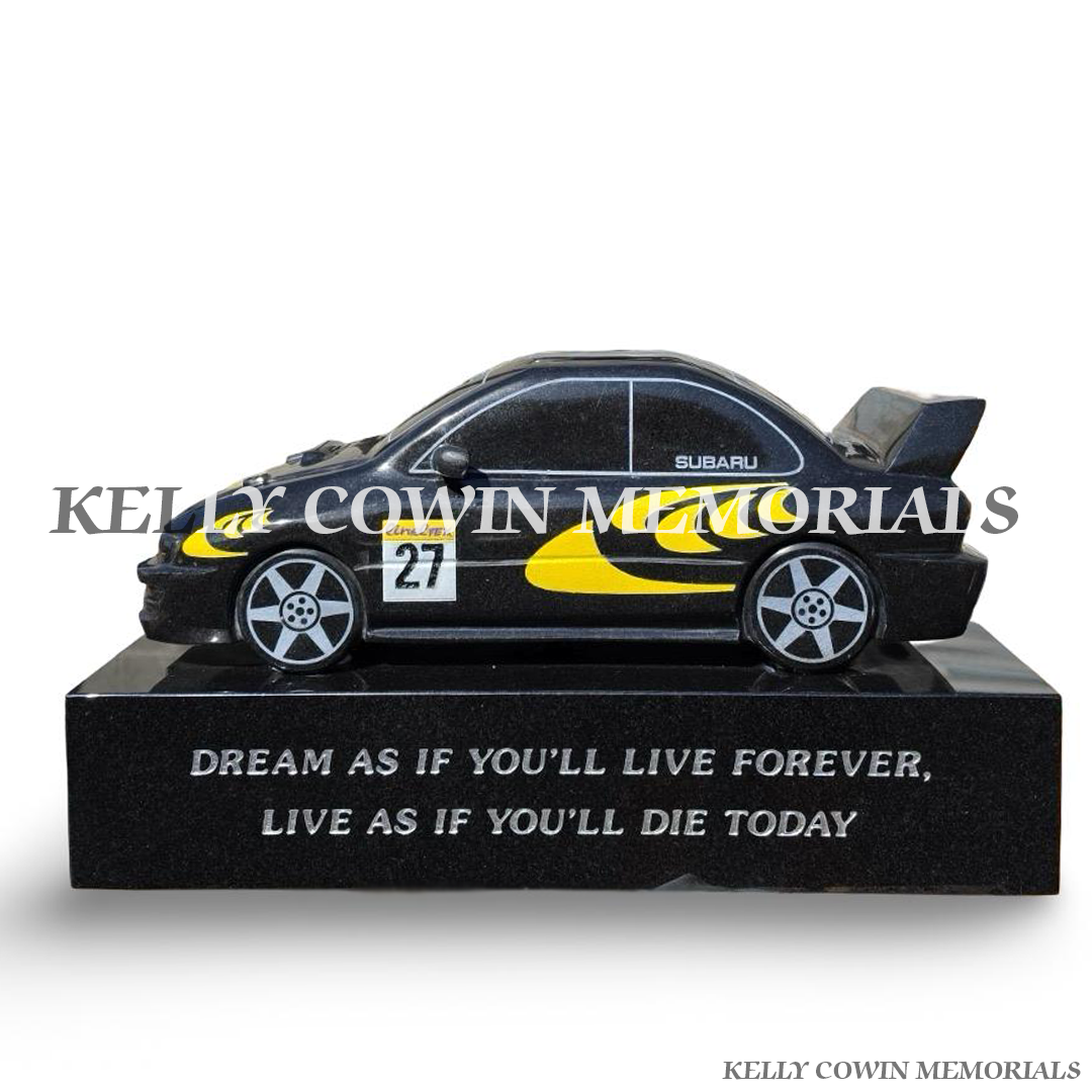 Side view of custom black granite Subaru car memorial with yellow rally detailing, wheels and rear spoiler.