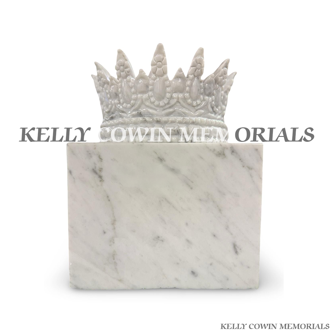 Side view of polished white marble crown accessory on block