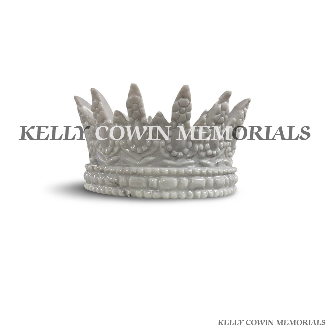 Close-up of gold engraved lettering on white marble crown memorial