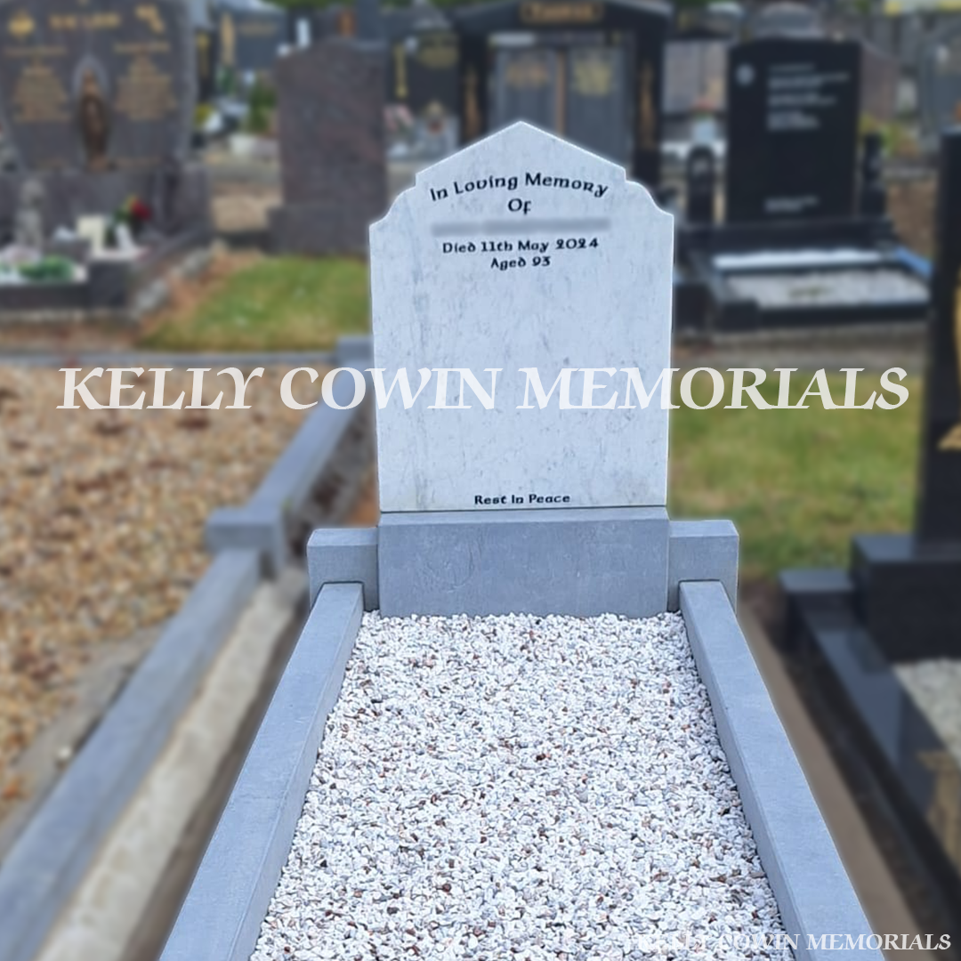 Close-up of black inscription on white marble headstone