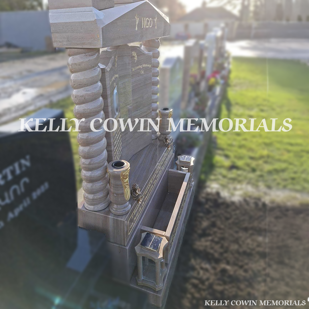 Side view of Woodlawn granite memorial with twisted pillars and bronze statues